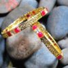Golden pair of bangles with white and red stones